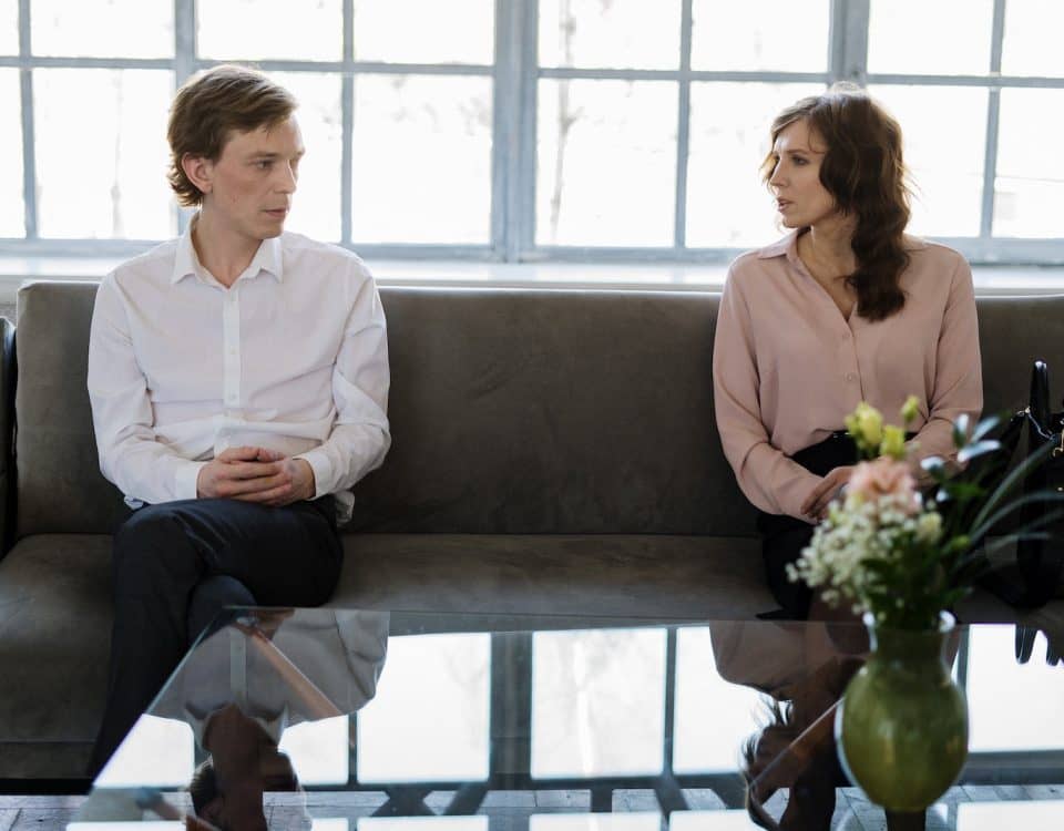 Man and Woman Sitting on Gray Couch
